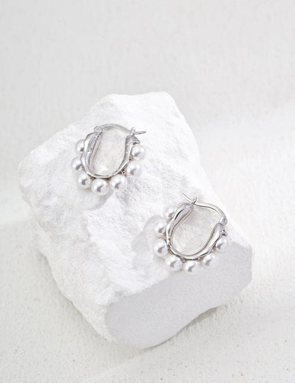 Silver Hoop Earrings-Radiant Pearl Huggies in Gold - Xaxa&Sie. Light up your look with these delicate sterling silver hoops, designed to showcase luminous imitation pearls for subtle everyday glamour.