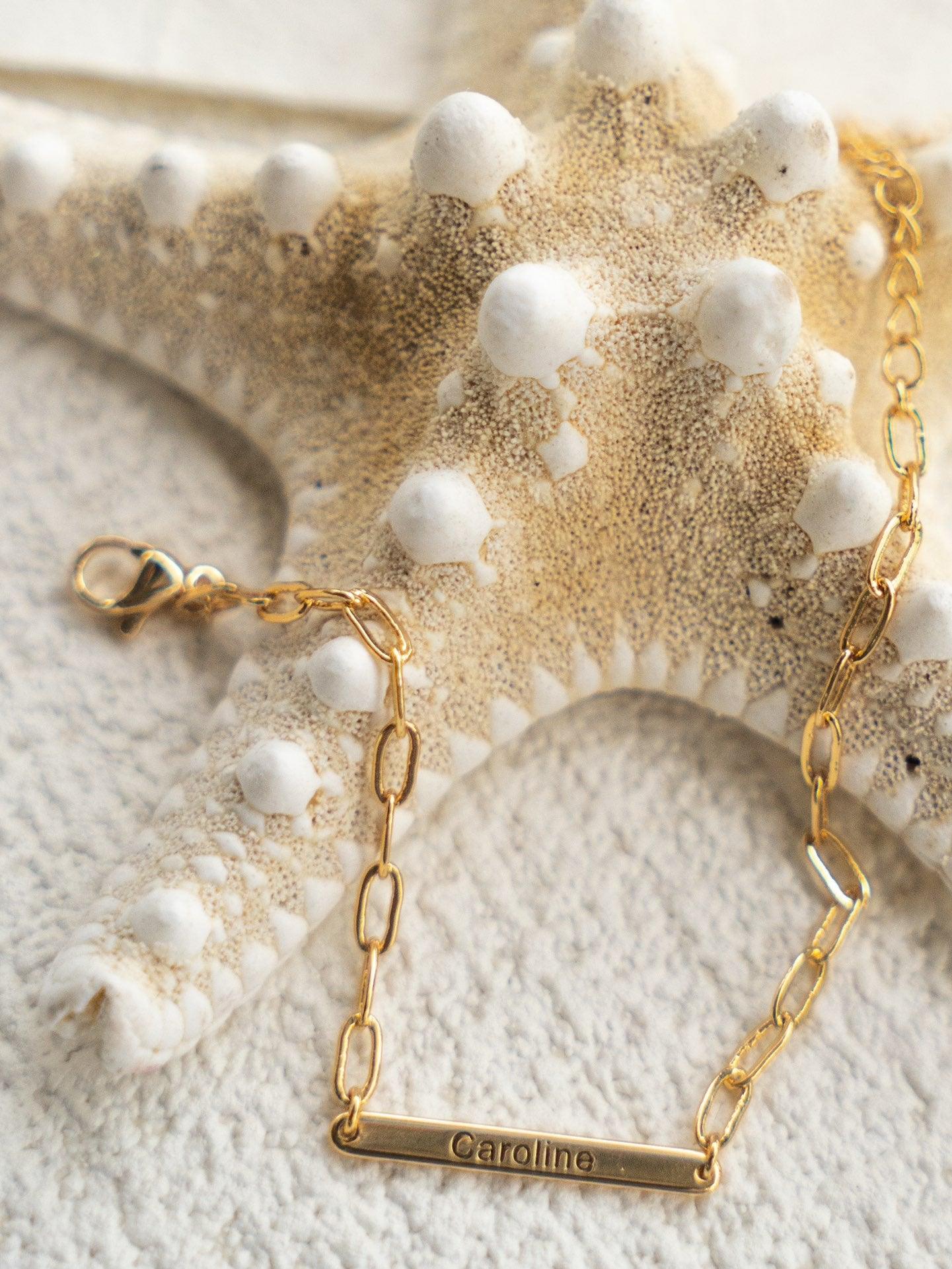 A trendy layered gold bracelet set with a modern charm, ideal for stacking