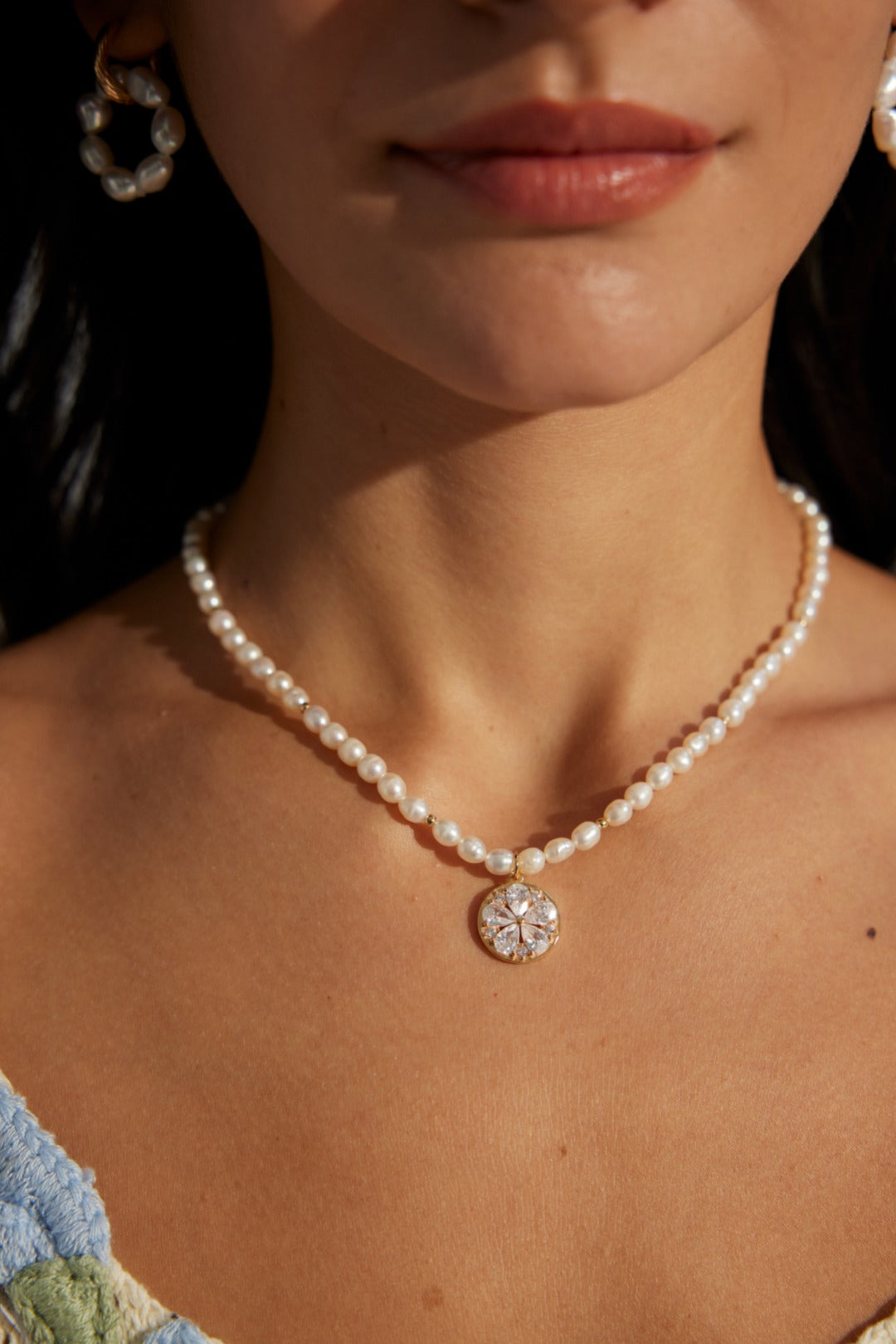 Lustrous pearls and a radiant gold pendant come together in this exquisite necklace