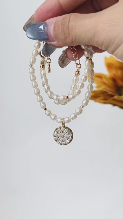 A timeless pearl necklace with a dainty gold pendant, designed for elegance and grace.